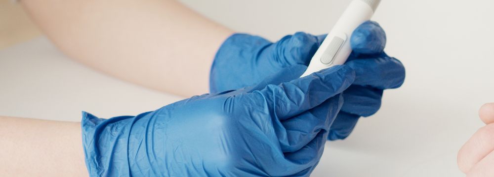 Person with gloves holding weight loss injection