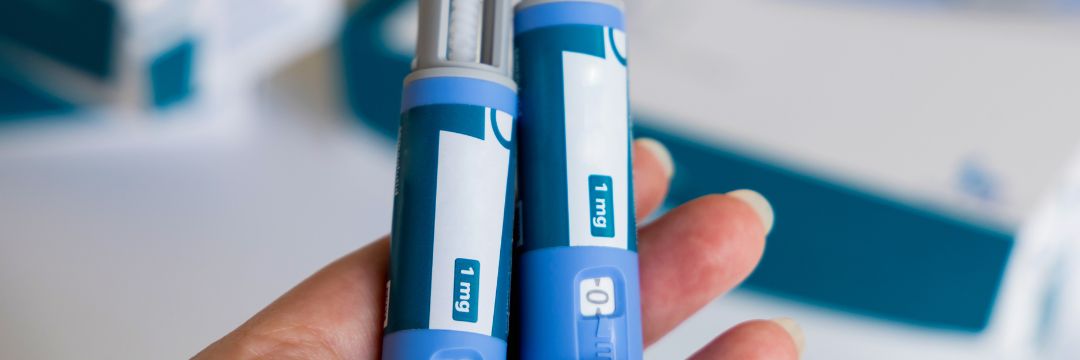 Woman holding two weight loss injections in hand 