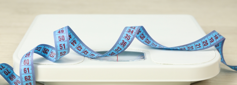 blue measuring tape coiled on white scale